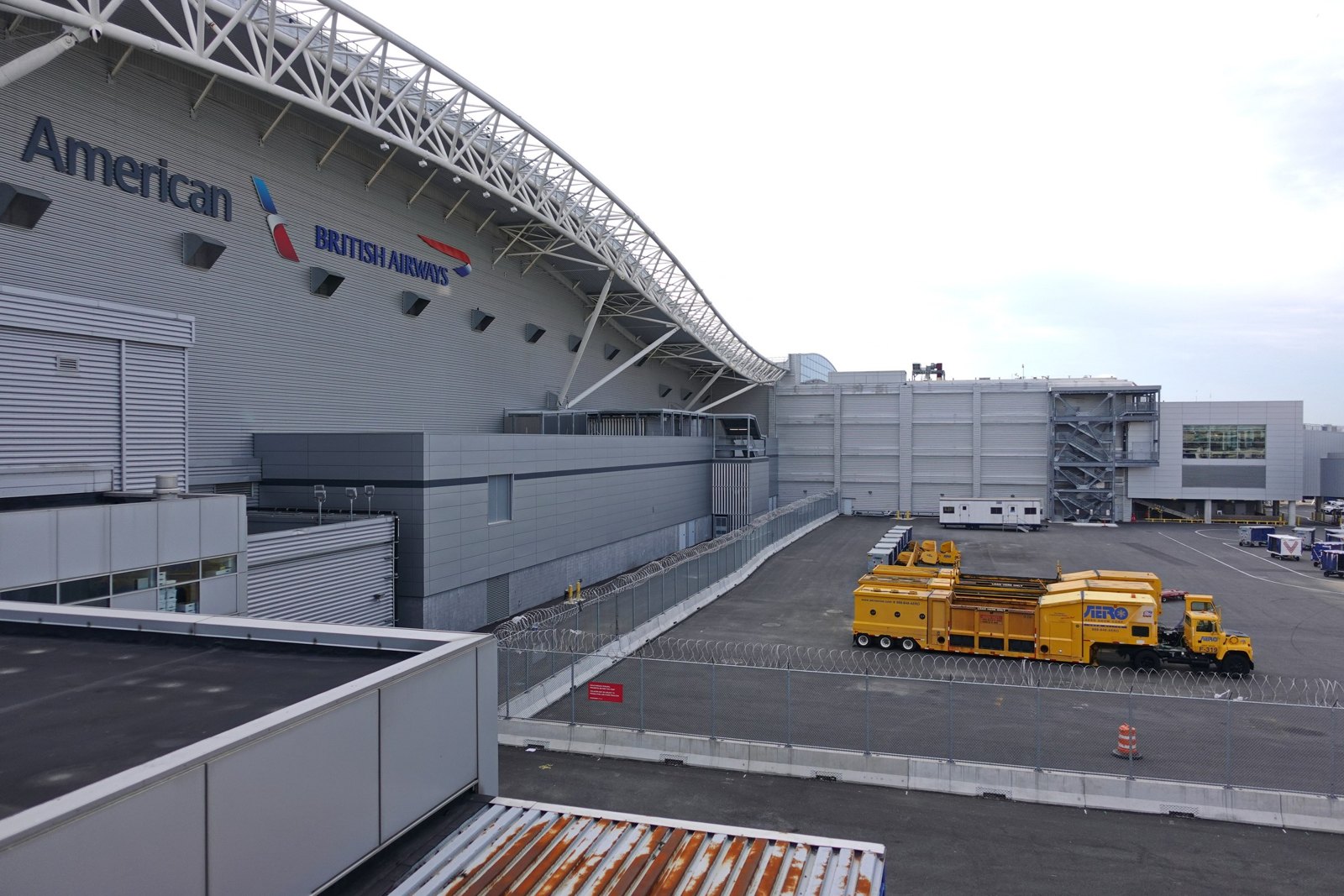 Exterior photograph of JFK Terminal 8 with the American Airlines and British Airways signage on the roofline